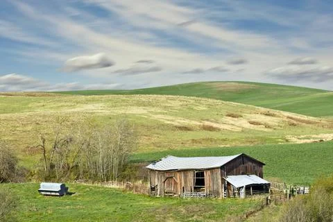 Old barn under a bright sky. Stock Photos