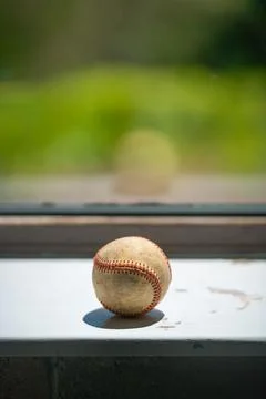 Old baseball ball on the windowsill, copy space. Stock Photos