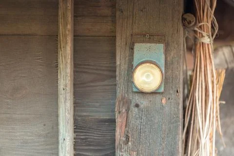 An old battery-powered flashlight hanging from a wooden beam. Photos