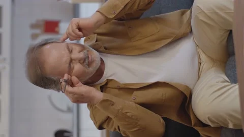 The old bearded man with a severe headache rubs his temples. Video stock 151998399