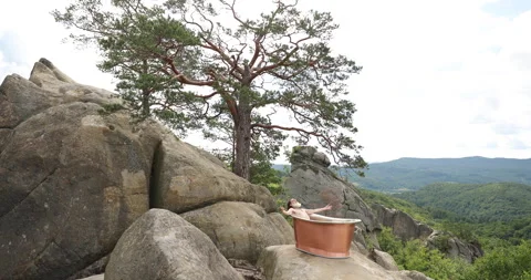 Old bearded man sitting in the bath on a rock. cast iron bath Stock Footage 164147352