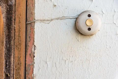 An old bell button on a white crumbling facade Foto stock