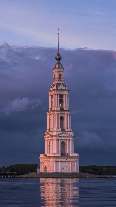 Old bell tower in  middle of lake. Time lapse of dramatic evening cloudy sky Stock Footage 293187549
