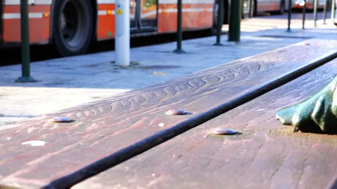 An old bench on the background of passing people and passing buses Stock Footage 93218146