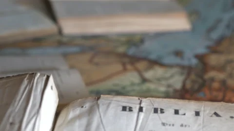 Old Bible book open on map. Tilt-up and rack focus Stock Footage 145625223