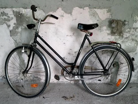 Old bicycle against a rustic wall Stock Photos
