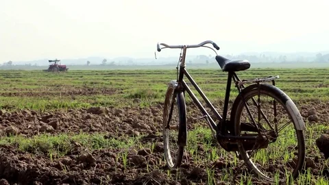 Old Bicycle On The Field With Distant Tractor Stock Footage 83248698