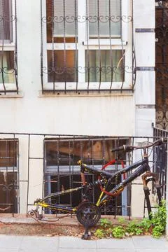 An old bicycle frame without wheels parked by a fence Stock Photos