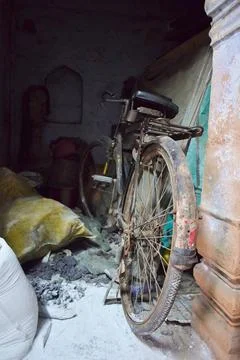 Old bicycle stored inside a weathered building Stock Photos