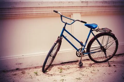 Old bicycle on wall in dark boder, vintage tone Фото
