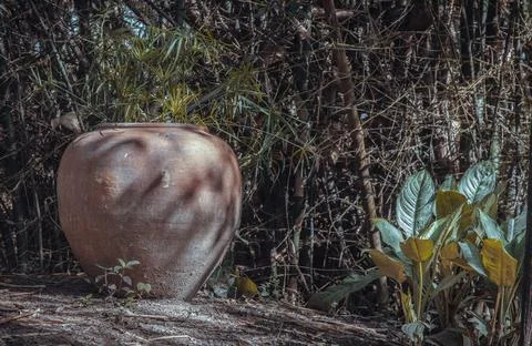Old big earthen jar or Large vintage clay jar for water storage on the ground Stock Photos