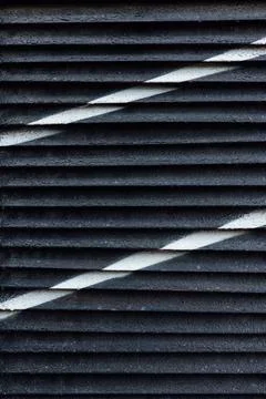 Old black blinds with diagonal white stripes Stock Photos