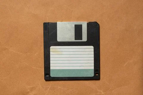 Old black floppy disk on brown paper , old technology Stock Photos