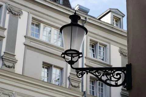 Old black lantern in front of a white rustic victorian house facade Stock Photos
