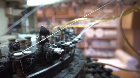 Old black metal spinning machine rotates moving threads Stock Footage 136400552