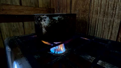 An old black pod is being used to cook dinner Stockbeeldmateriaal 336918482