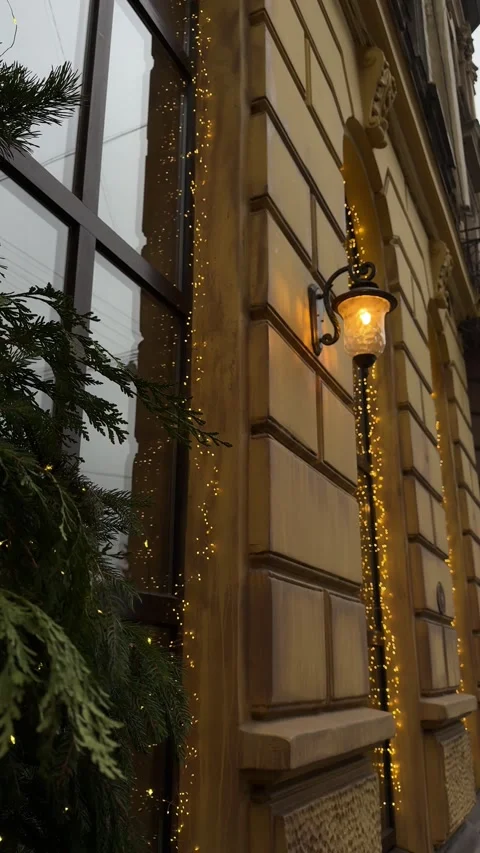 Old black retro lantern with light bulb on the wall of building on the street on Stock Footage 322662101