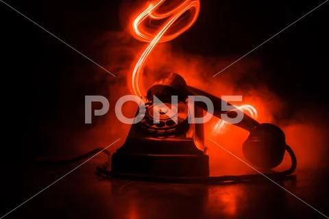 Old black telephone on old wood plank with art dark background with fog and t Stock Photos