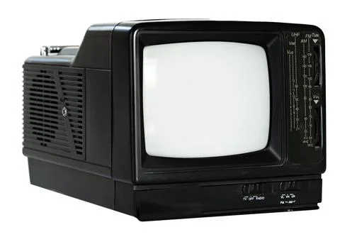 Old black television set with dials sitting on a table in a living room during Stock Photos
