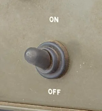 Old black toggle switch on green surface - on Stock Photos