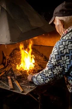 Old blacksmith burning coal. Blacksmith setting fire for molting metal to be  Stock Photos