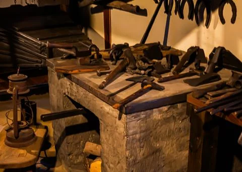 Old blacksmith workshop with tools on a stone bench Stock Photos