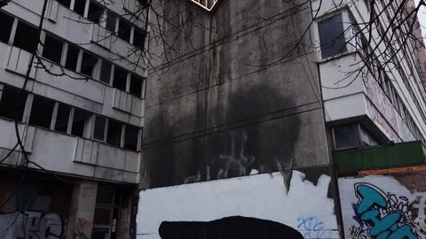 Old block of flats with destroyed windows and graffiti in East Europe Stock Footage 120651129