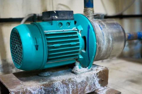 Old blue engine with a pump standing on a metal stand. Stock Photos