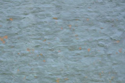 Old blue flaking paint on wall with orange underneath Stock Photos