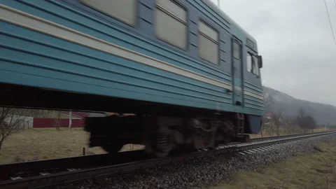 Old blue passenger train moves through village in highlands. Evaporation in moun Stock Footage 145976951