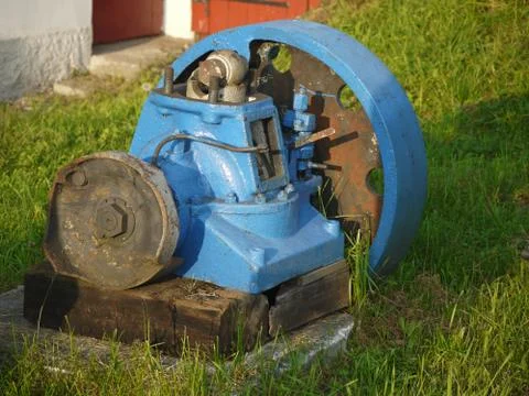 Old blue rusty engine laying in grass Stock Photos