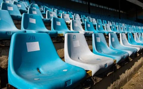 Old blue seats on an empty stadium for football fans Stock Photos