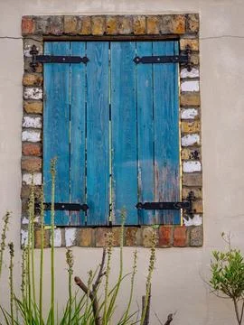 Old Blue shutters on square window for use as background Stock Photos