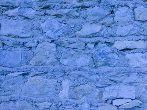 The old blue stone wall. Blue stone background. The texture of the stone. Stock Photos