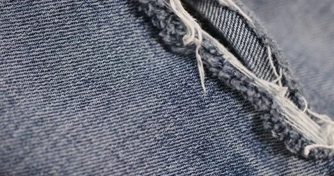 Old blue torn jeans from long-term wear, part of jeans made of cotton fabric Stock Footage 324877436