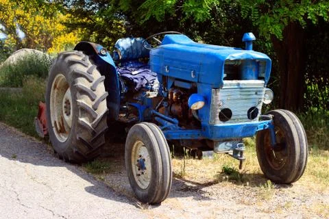 Old blue tractor on the road Stock Photos