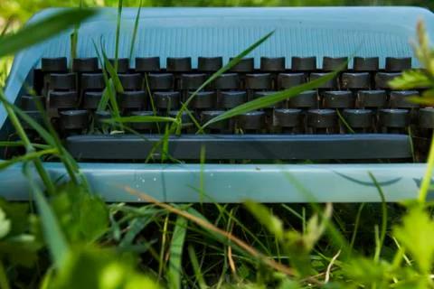 Old blue typewriter on the grass Stock Photos