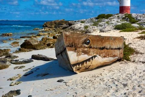 Old boat on the beach and lighthouse Stock Photos