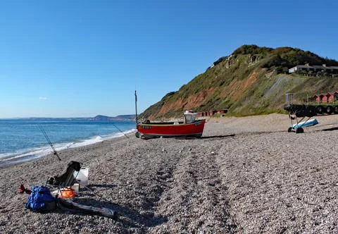 An old boat on the beach at Branscombe in Devon, England. Fishermen's equipme Stock Photos