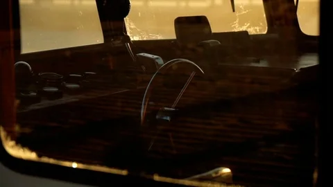 Old boat cabin with steering hand wheel and dashboard inside through the window Stock Footage 73824740