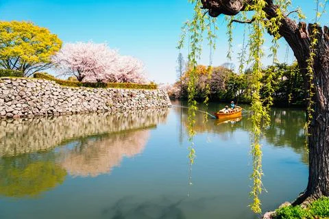 Old boat on the canal with spring cherry blossoms at Himeji Castle in Japan Stock Photos