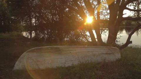 Old boat lying on the bank of a river during the sunset 스톡 동영상 80929509