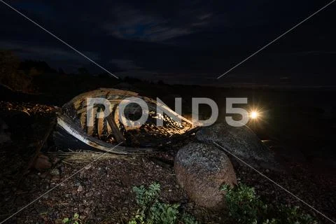 Old boat, shore, evening light, sunset, clouds and architecture concept in th Stock Photos