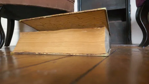 Old book falling to the floor in slow mo... | Stock Video | Pond5