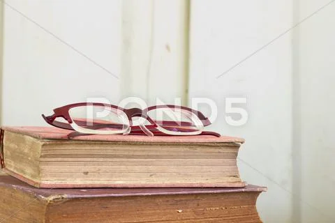 Old book pages texture with eye glasses. Stock Photos
