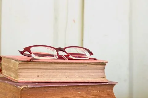 Old book pages texture with eye glasses. Stock Photos