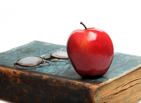 Old book with red apple Stock Photos