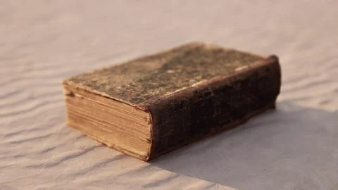 Old book on the sand beach Stock Illustration