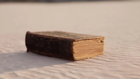 Old book on the sand beach Stock Illustration