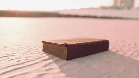 Old book on the sand beach Stock Illustration